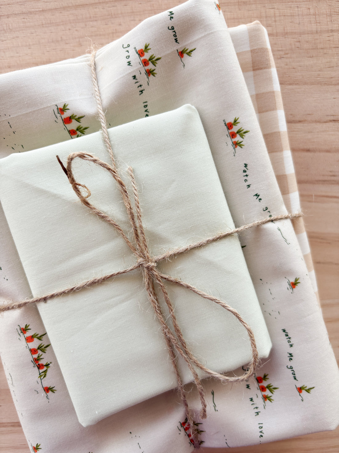 Fabric bundle with carrots with creams whites and pinks tied with twine