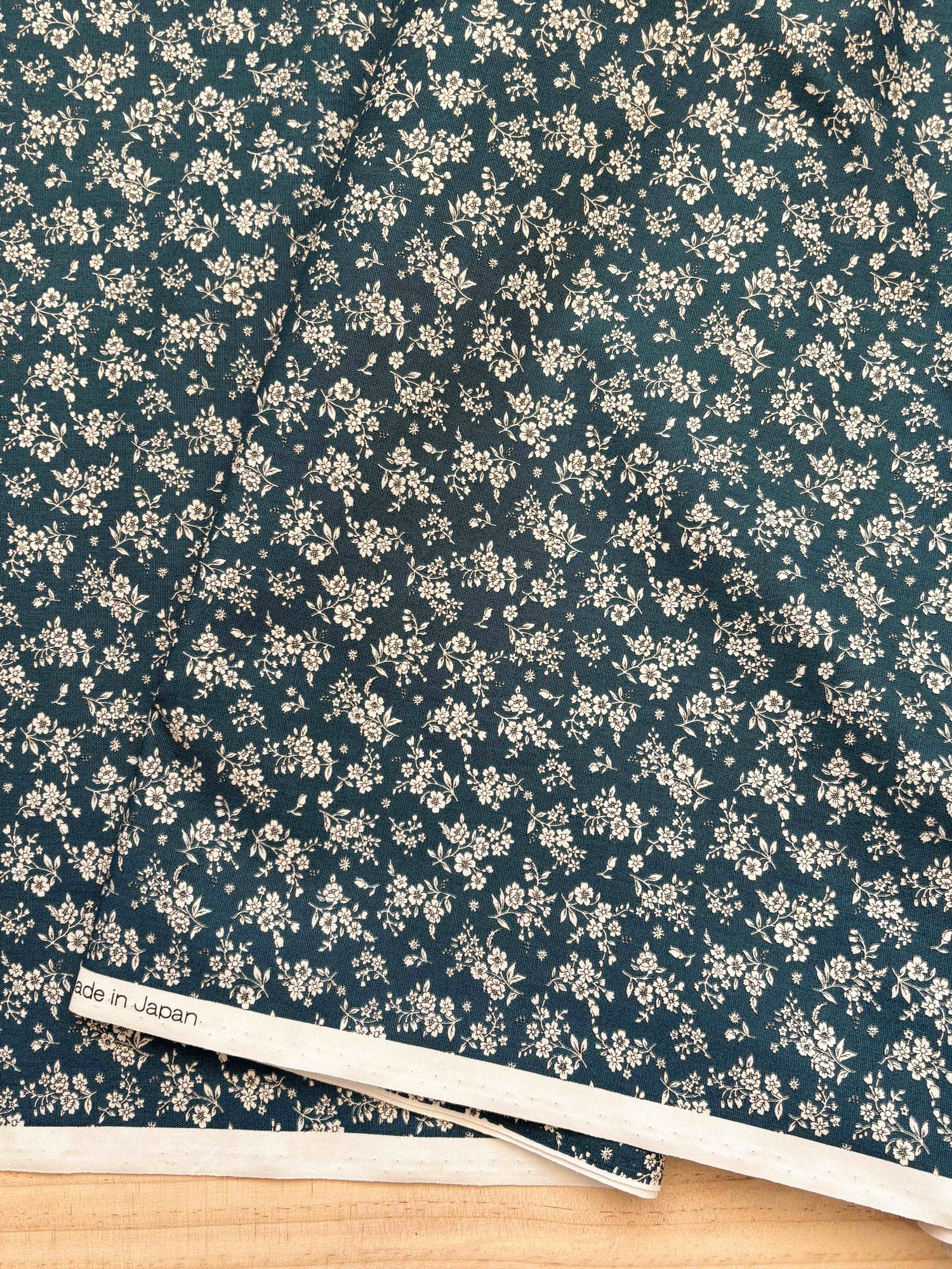 Close up of fabric with white floral with dark navy background