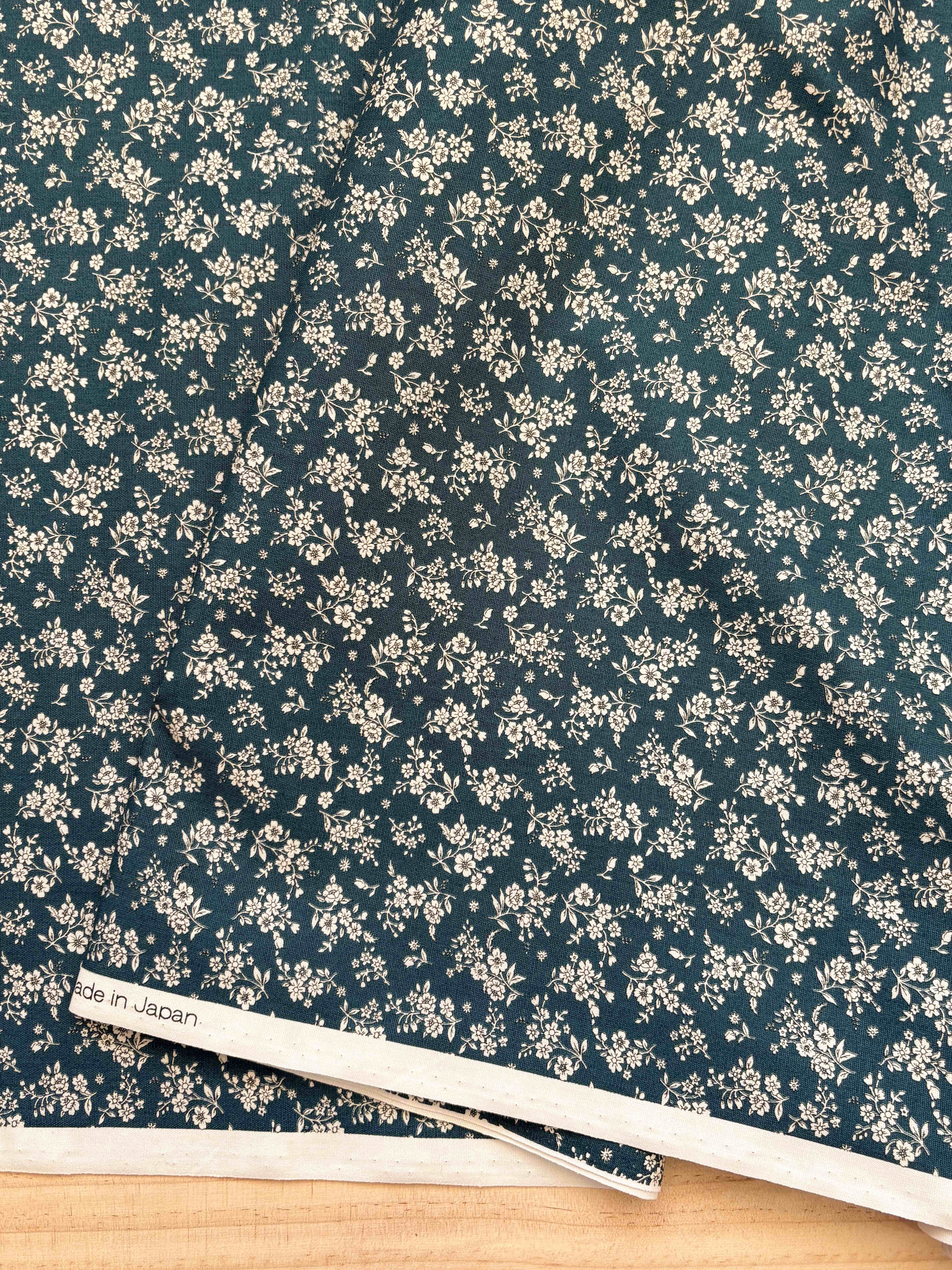 Close up of fabric with white floral with dark navy background