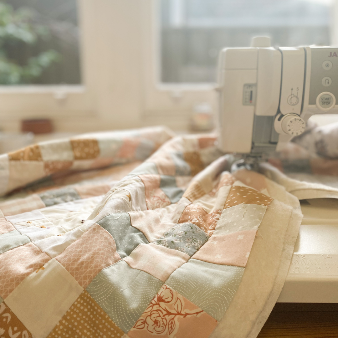 Sewing machine being used to sew a quilt
