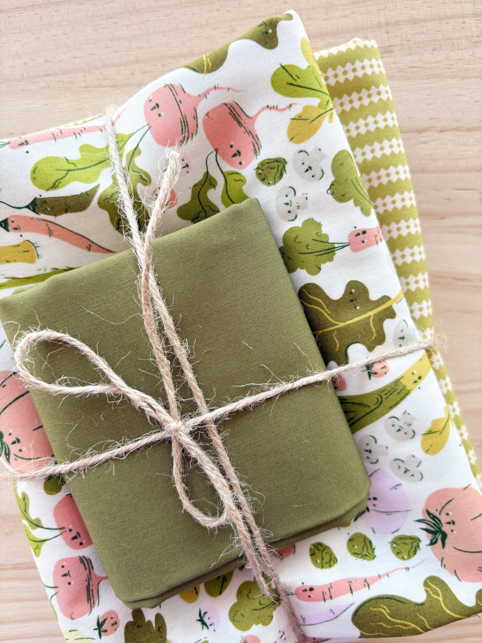 Bundle of fabric with variety of vegetables with greens and whites tied with twine