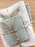 Bundle of fabric with light blues and bunny Beatrix Potter print tied with twine.